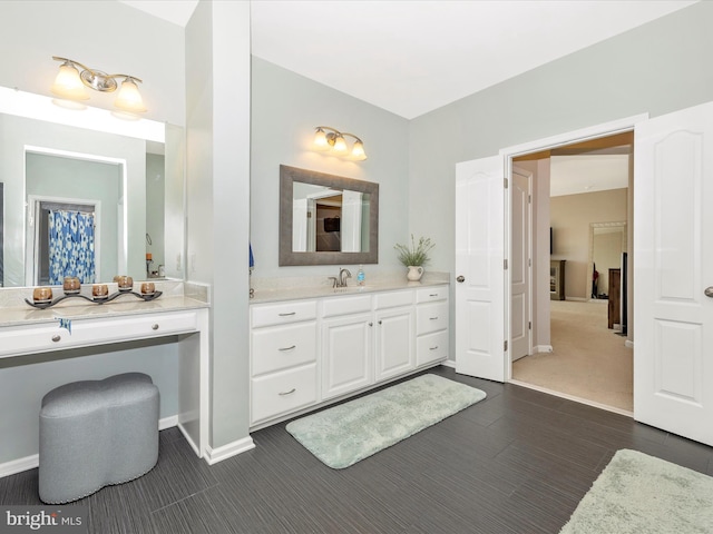 bathroom with baseboards, wood finished floors, and vanity