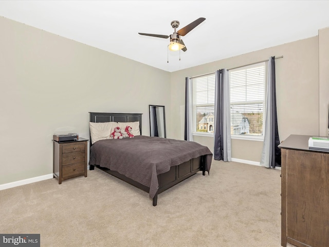 bedroom featuring ceiling fan, baseboards, and light colored carpet