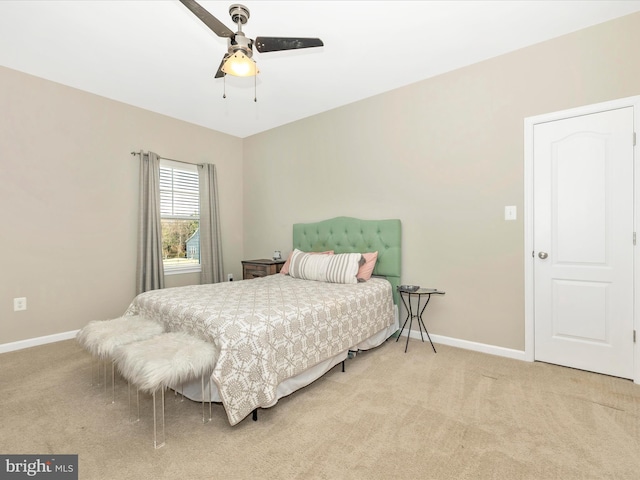 bedroom featuring baseboards, a ceiling fan, and light colored carpet