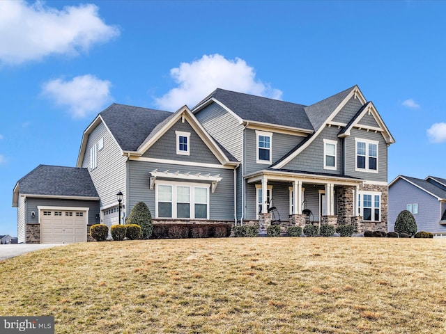 craftsman inspired home with stone siding, a shingled roof, a front lawn, and a porch