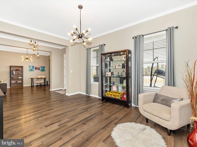 living area featuring ornamental molding, wood finished floors, baseboards, and an inviting chandelier