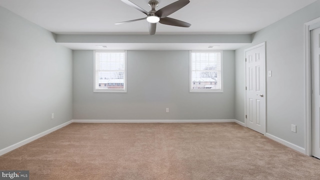 empty room featuring light colored carpet, baseboards, and ceiling fan