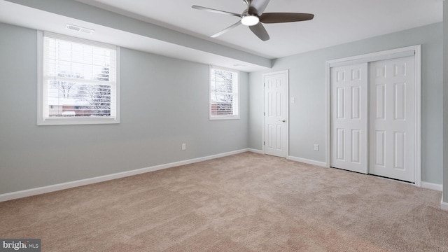 unfurnished bedroom featuring baseboards, visible vents, carpet floors, and ceiling fan