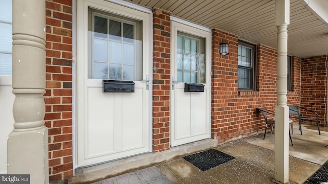 entrance to property with brick siding and covered porch