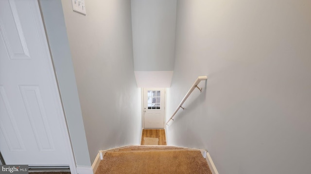 stairs featuring wood finished floors and baseboards