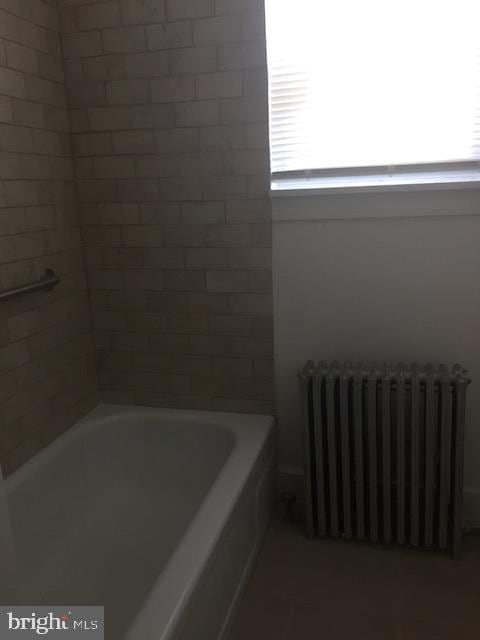 bathroom with radiator and a bathtub