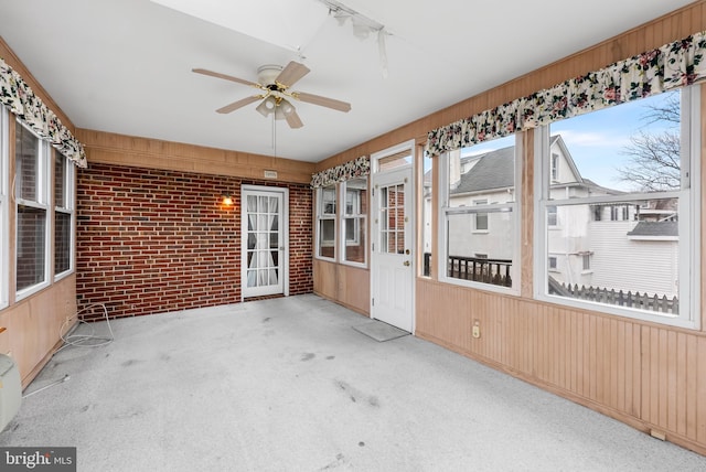 unfurnished sunroom featuring ceiling fan