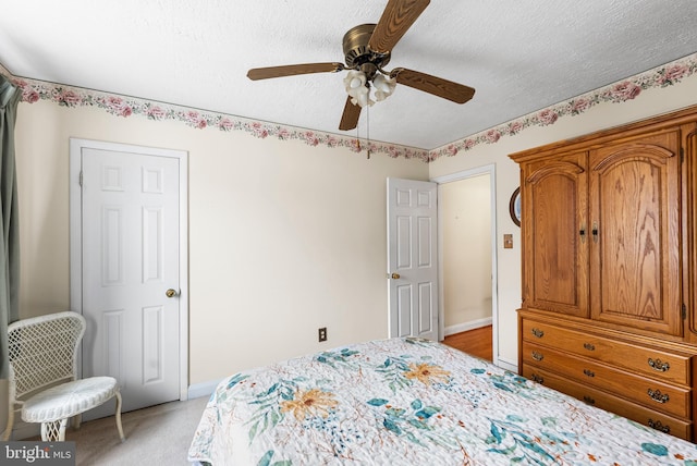 carpeted bedroom featuring ceiling fan and a textured ceiling