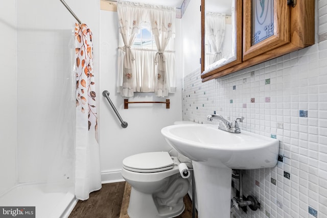 bathroom featuring a shower with curtain, toilet, hardwood / wood-style floors, and tasteful backsplash