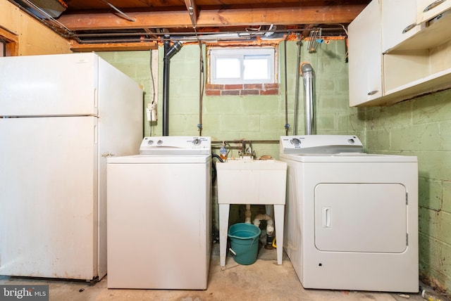 laundry room featuring cabinets, sink, and independent washer and dryer