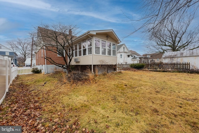 back of house featuring a lawn and a sunroom