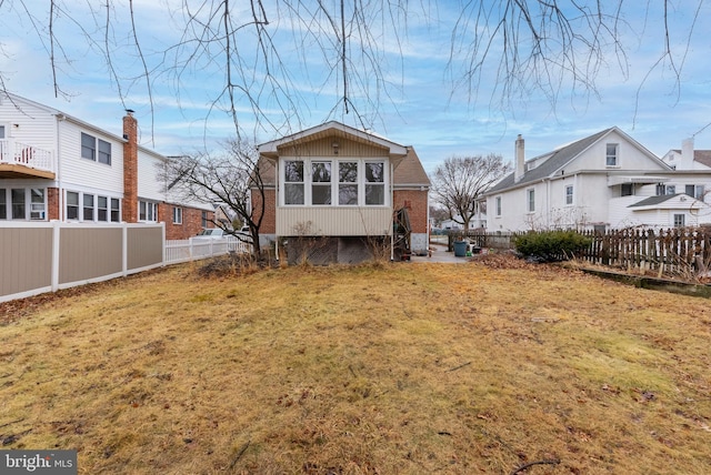 rear view of house featuring a lawn