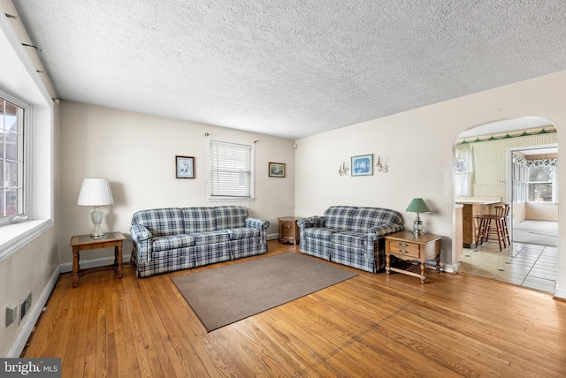 living room featuring wood-type flooring and a textured ceiling