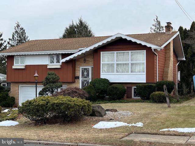 view of front facade featuring a garage and a front lawn