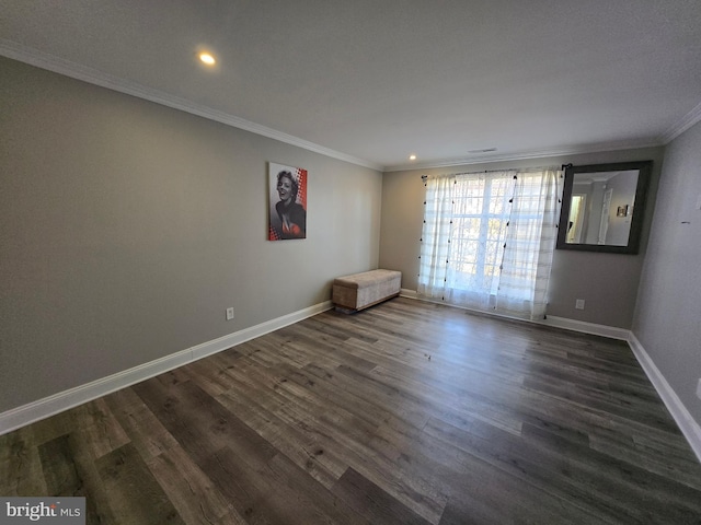 spare room with dark wood-style flooring, baseboards, and ornamental molding