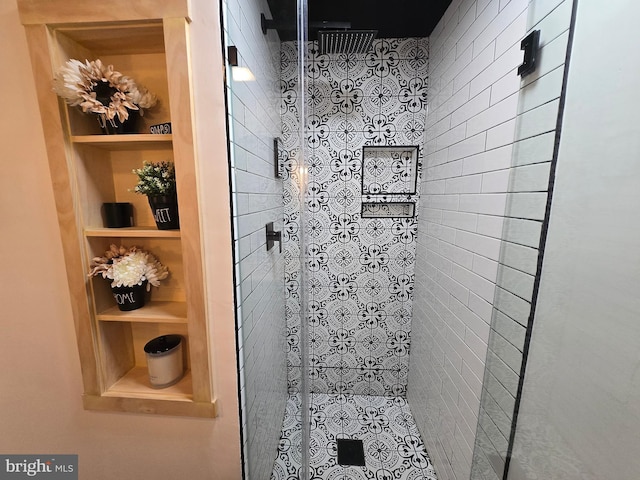 bathroom with built in features and a tile shower