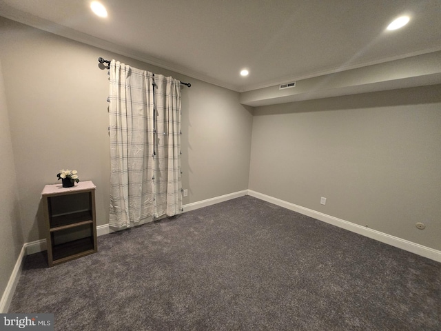 finished basement with visible vents, crown molding, baseboards, dark carpet, and recessed lighting