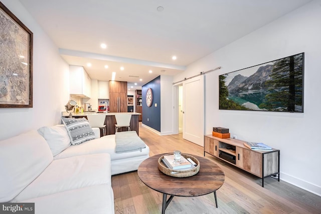 living room with light hardwood / wood-style floors and a barn door