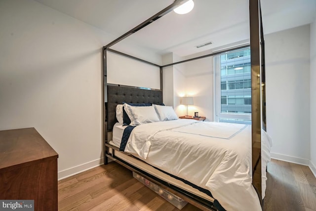 bedroom featuring wood-type flooring and floor to ceiling windows