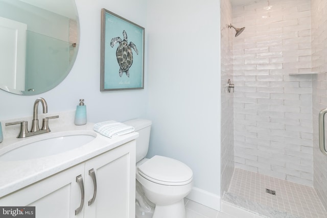 bathroom featuring vanity, a tile shower, and toilet