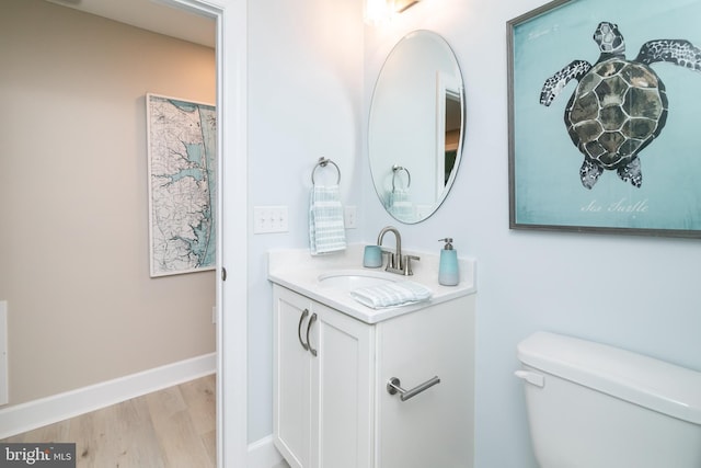 bathroom featuring vanity, wood-type flooring, and toilet