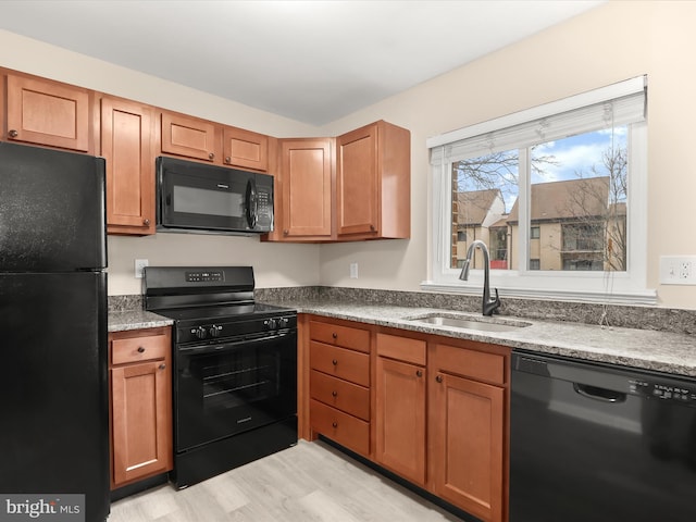 kitchen featuring light hardwood / wood-style floors, sink, and black appliances