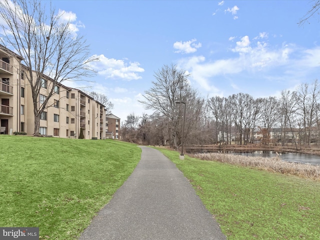 view of community with a water view and a yard