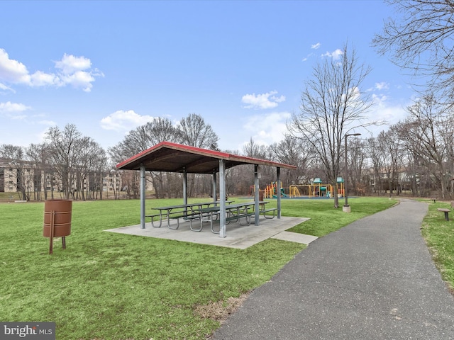 view of home's community with a playground, a patio area, and a lawn