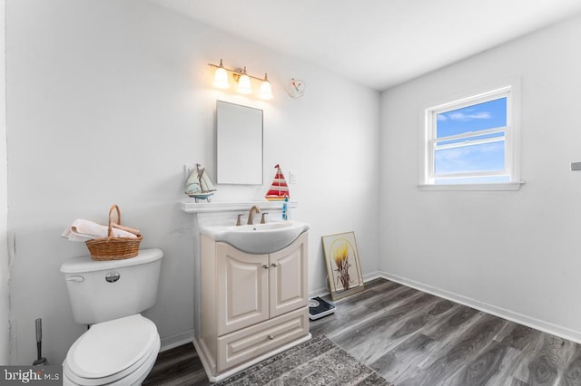 bathroom with hardwood / wood-style flooring, vanity, and toilet