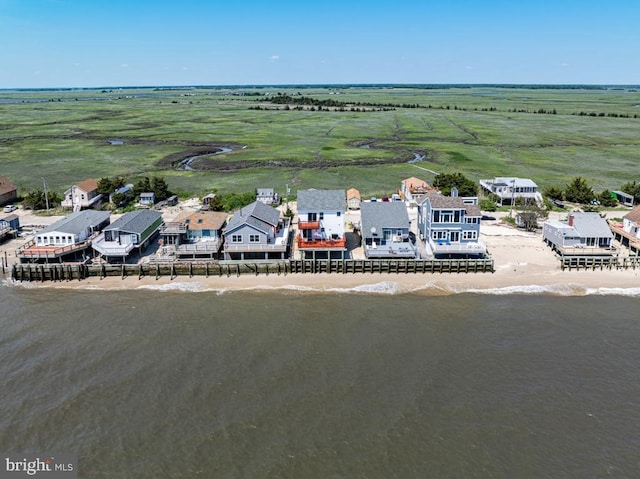 drone / aerial view with a water view, a view of the beach, and a rural view