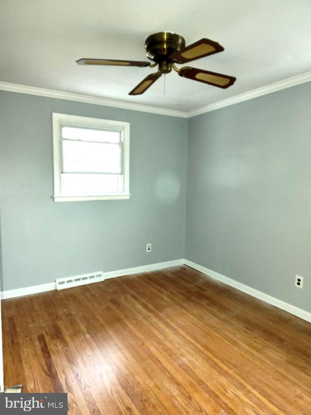 spare room featuring crown molding, wood-type flooring, and ceiling fan