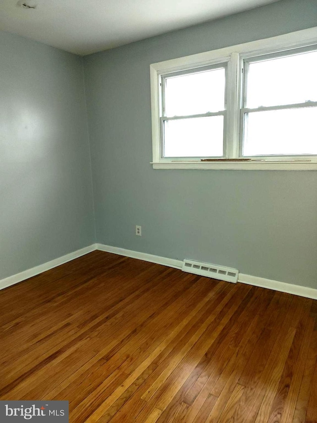 spare room featuring hardwood / wood-style floors and a healthy amount of sunlight