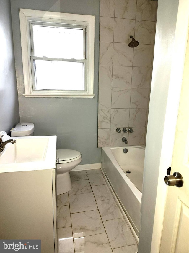 full bathroom featuring tiled shower / bath combo, vanity, and toilet