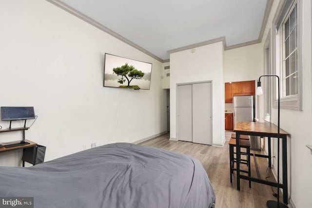 bedroom featuring crown molding, lofted ceiling, stainless steel fridge, and light hardwood / wood-style flooring