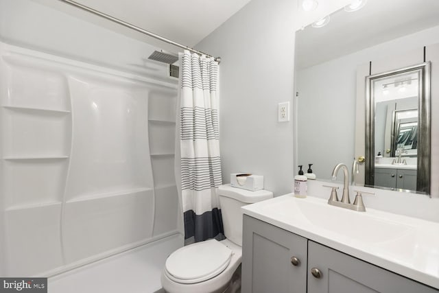 bathroom with vanity, curtained shower, and toilet