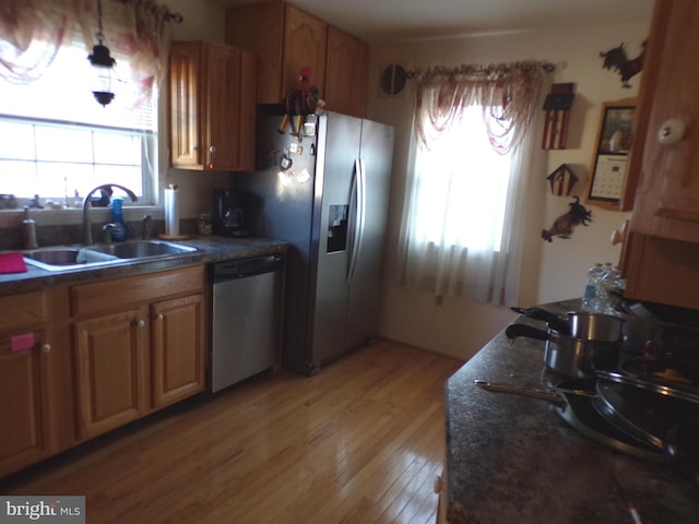 kitchen featuring appliances with stainless steel finishes, sink, and light wood-type flooring