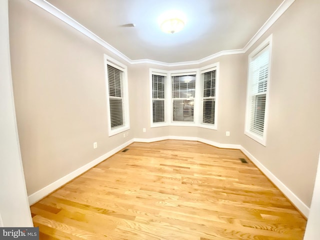 unfurnished dining area with ornamental molding and light hardwood / wood-style floors