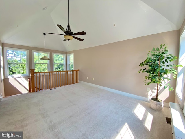 empty room with lofted ceiling, ceiling fan, and carpet