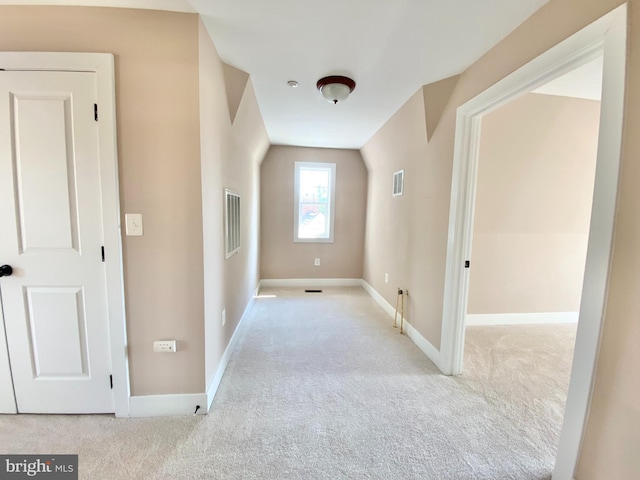 corridor featuring lofted ceiling and light carpet