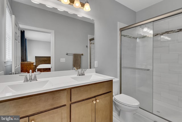 bathroom with vanity, toilet, and a shower with shower door