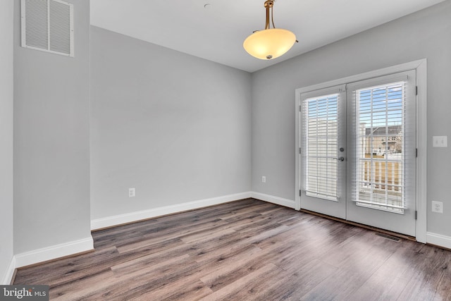 spare room featuring dark hardwood / wood-style floors and french doors