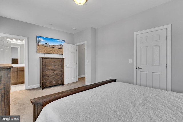 bedroom with light colored carpet and ensuite bath