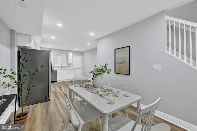 dining space with sink and light hardwood / wood-style floors