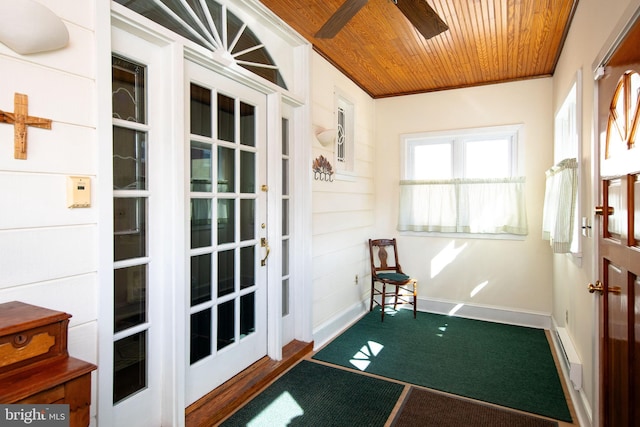 entryway with a ceiling fan, a baseboard radiator, wood ceiling, and baseboards