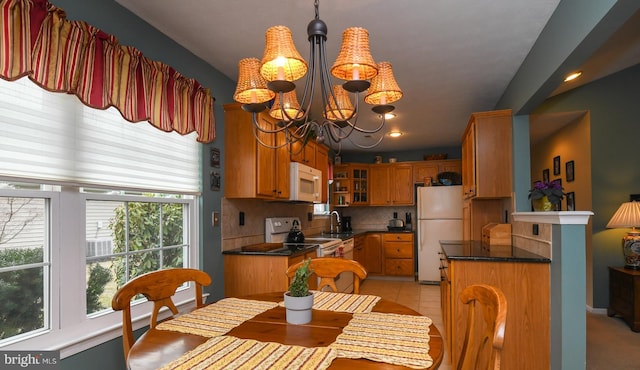 dining area with light tile patterned floors, sink, and a chandelier