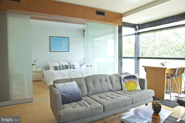 interior space with light wood-style floors, a healthy amount of sunlight, and visible vents