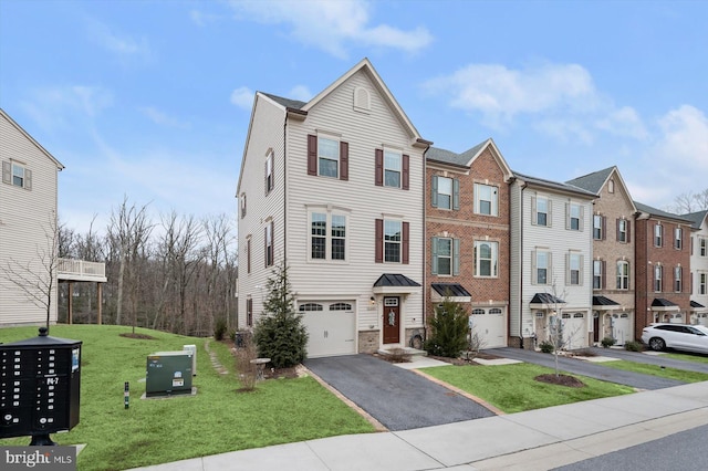 townhome / multi-family property with aphalt driveway, a garage, and a front lawn