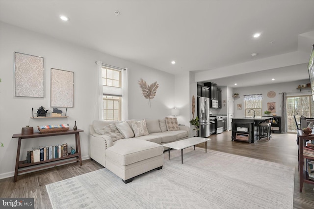 living area with recessed lighting, plenty of natural light, and wood finished floors