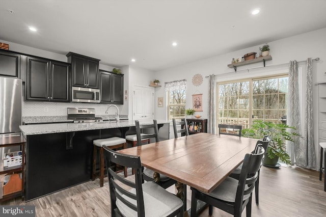 dining space with light wood-style floors and recessed lighting