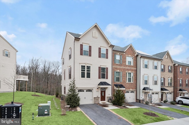 multi unit property featuring driveway, a garage, and a front yard